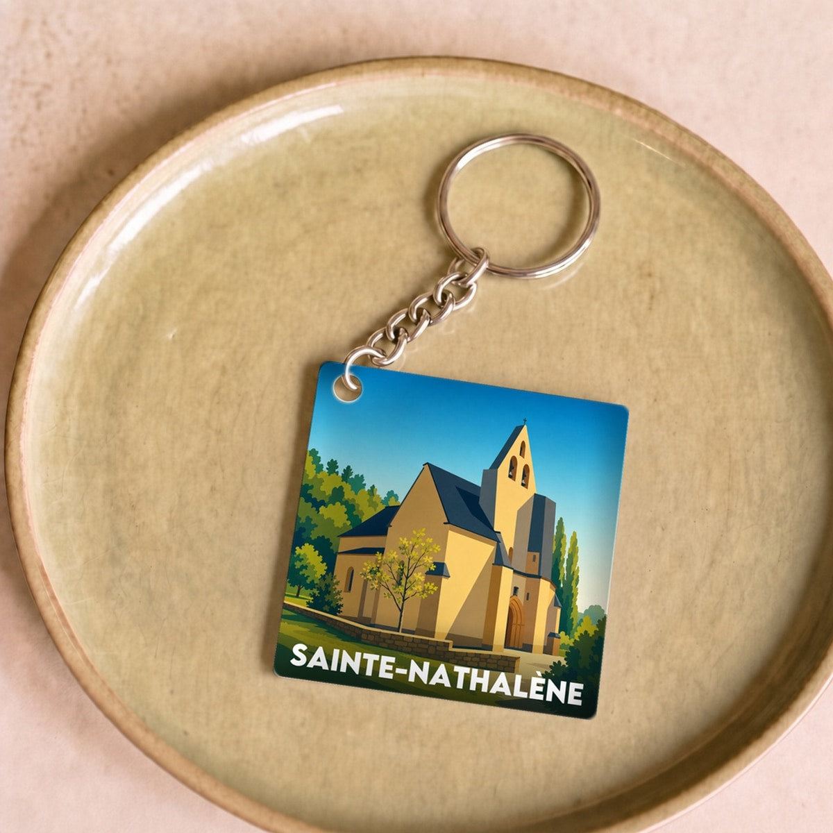 Porte-clés souvenir de la ville de Sainte-Nathalène avec une illustration stylisée.