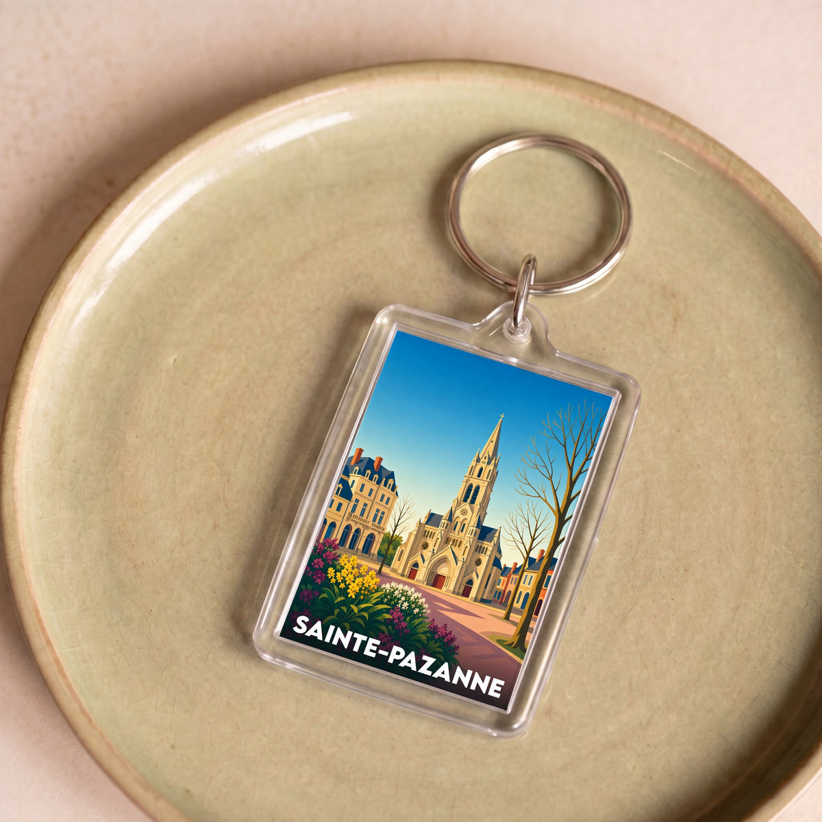 Porte-clés souvenir de la ville de Sainte-Pazanne avec une illustration stylisée d'une église.