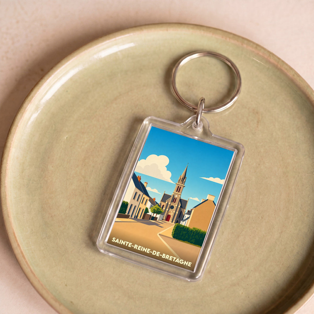 Porte-clés souvenir de la ville de Sainte-Reine-de-Bretagne avec une illustration stylisée.