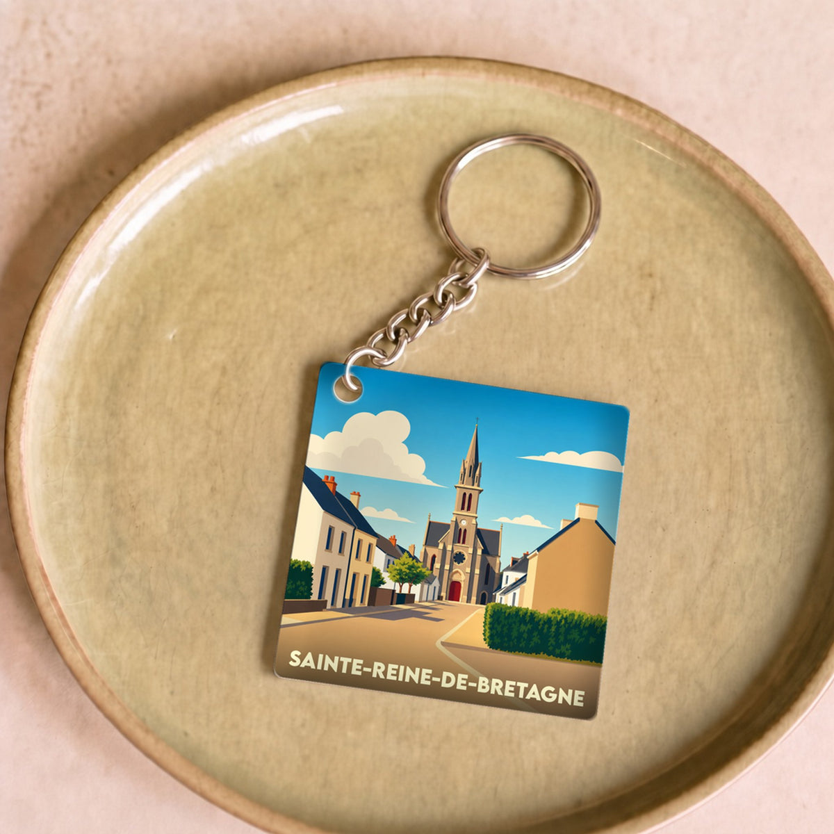 Porte-clés souvenir de la ville de Sainte-Reine-de-Bretagne avec une illustration stylisée.