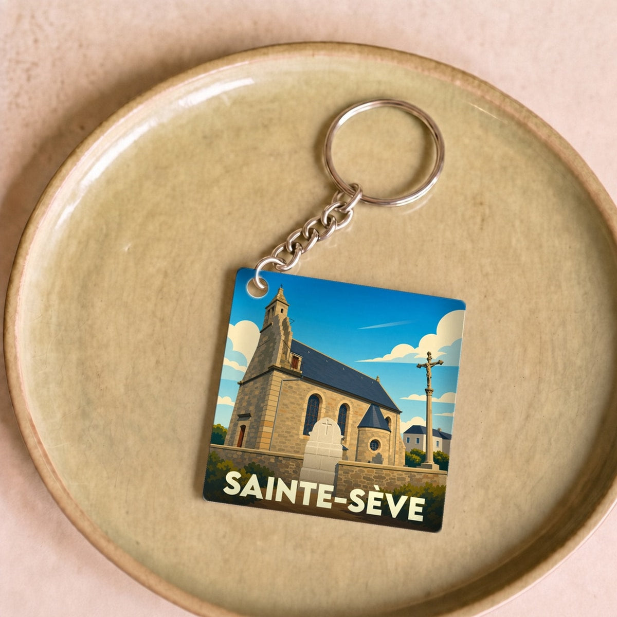 Porte-clés souvenir de la ville de Sainte-Sève avec une illustration stylisée de son église.