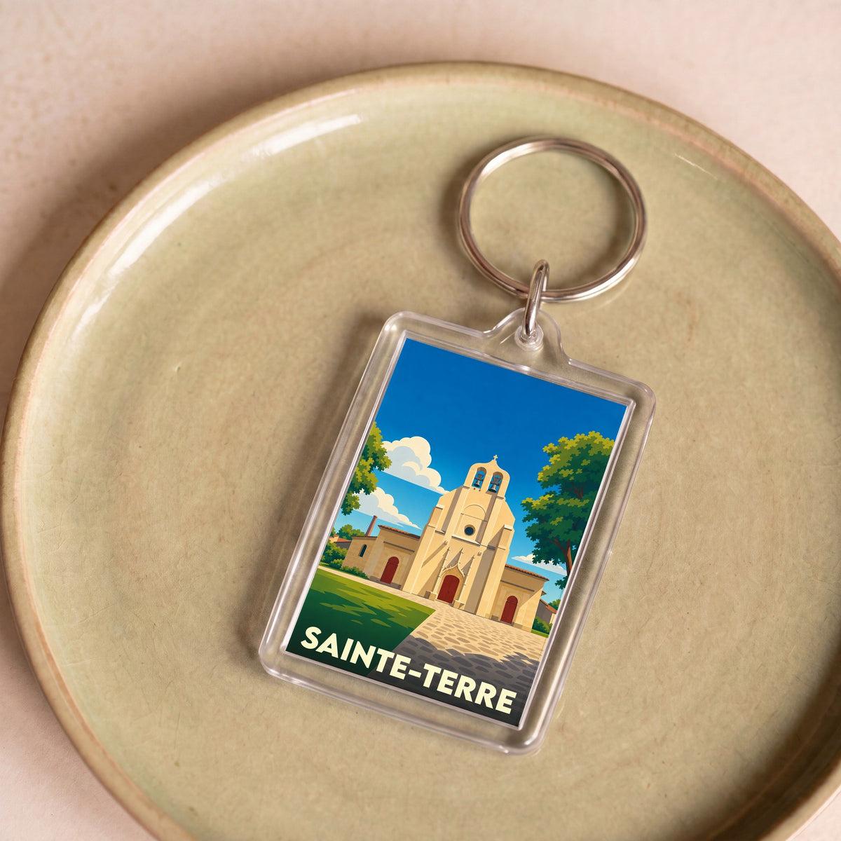 Porte-clés souvenir de la ville de Sainte-Terre avec une illustration stylisée de son église.