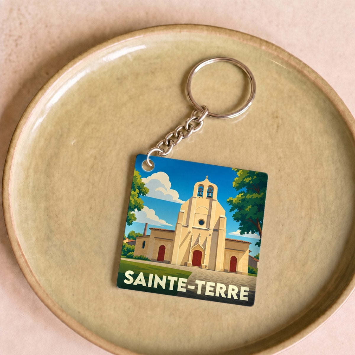 Porte-clés souvenir de la ville de Sainte-Terre avec une illustration stylisée de son église.