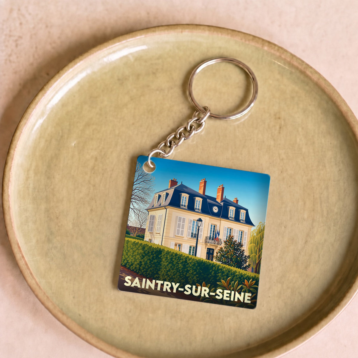 Porte-clés souvenir de la ville de Saintry-sur-Seine avec une illustration stylisée d'un bâtiment historique.