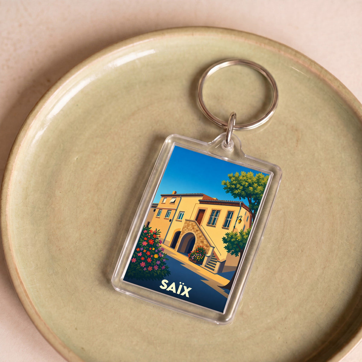 Porte-clés souvenir de la ville de Saïx avec une illustration stylisée.