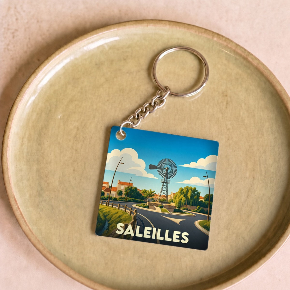 Porte-clés souvenir de la ville de Saleilles avec une illustration stylisée d'un moulin à vent.