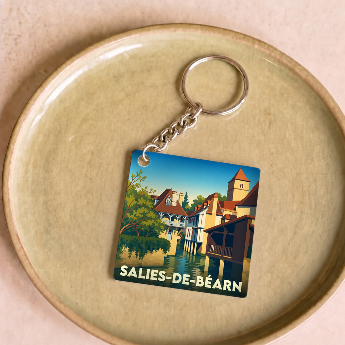 Porte-clés souvenir de la ville de Salies-de-Béarn avec une illustration stylisée.