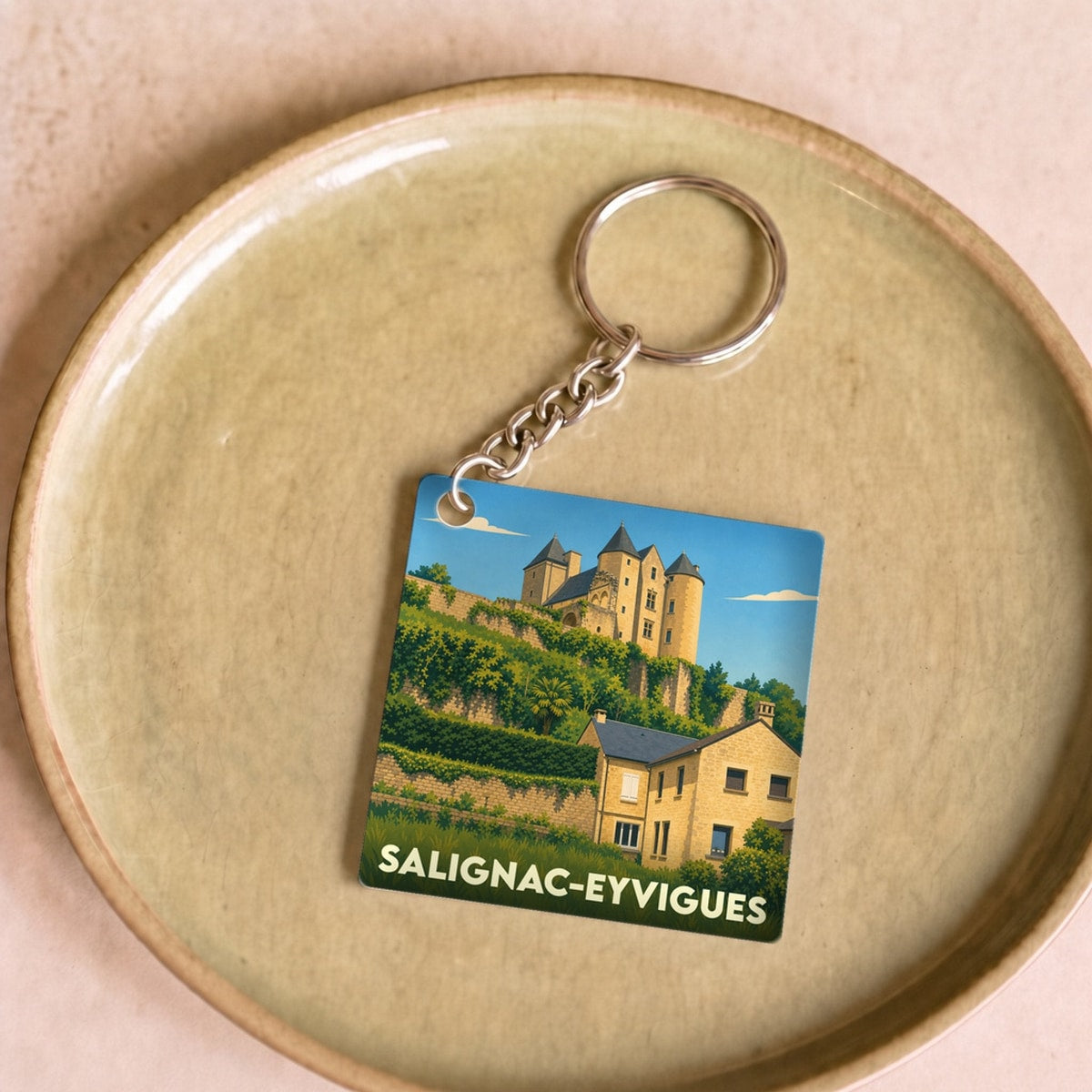 Porte-clés souvenir de la ville de Salignac-Eyvigues avec une illustration stylisée du château.