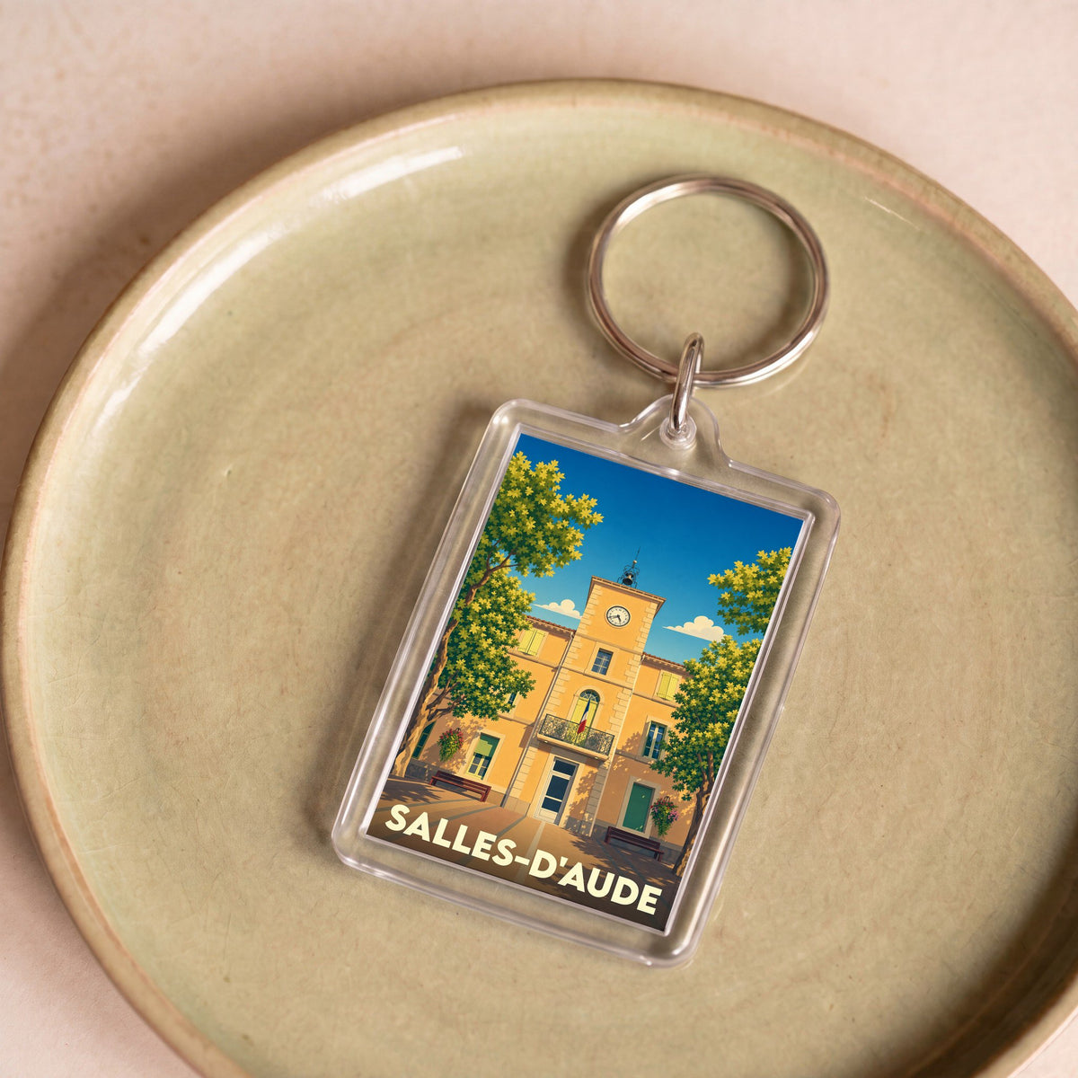 Porte-clés souvenir de la ville de Salles-d'Aude avec une illustration stylisée de sa mairie.
