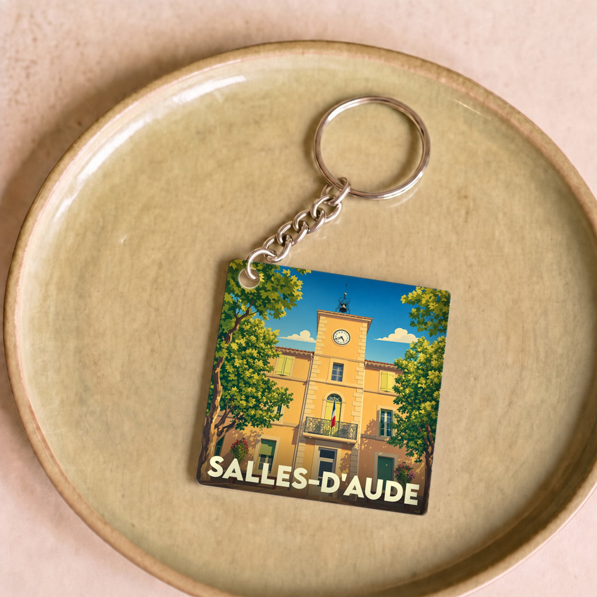 Porte-clés souvenir de la ville de Salles-d'Aude avec une illustration stylisée de sa mairie.