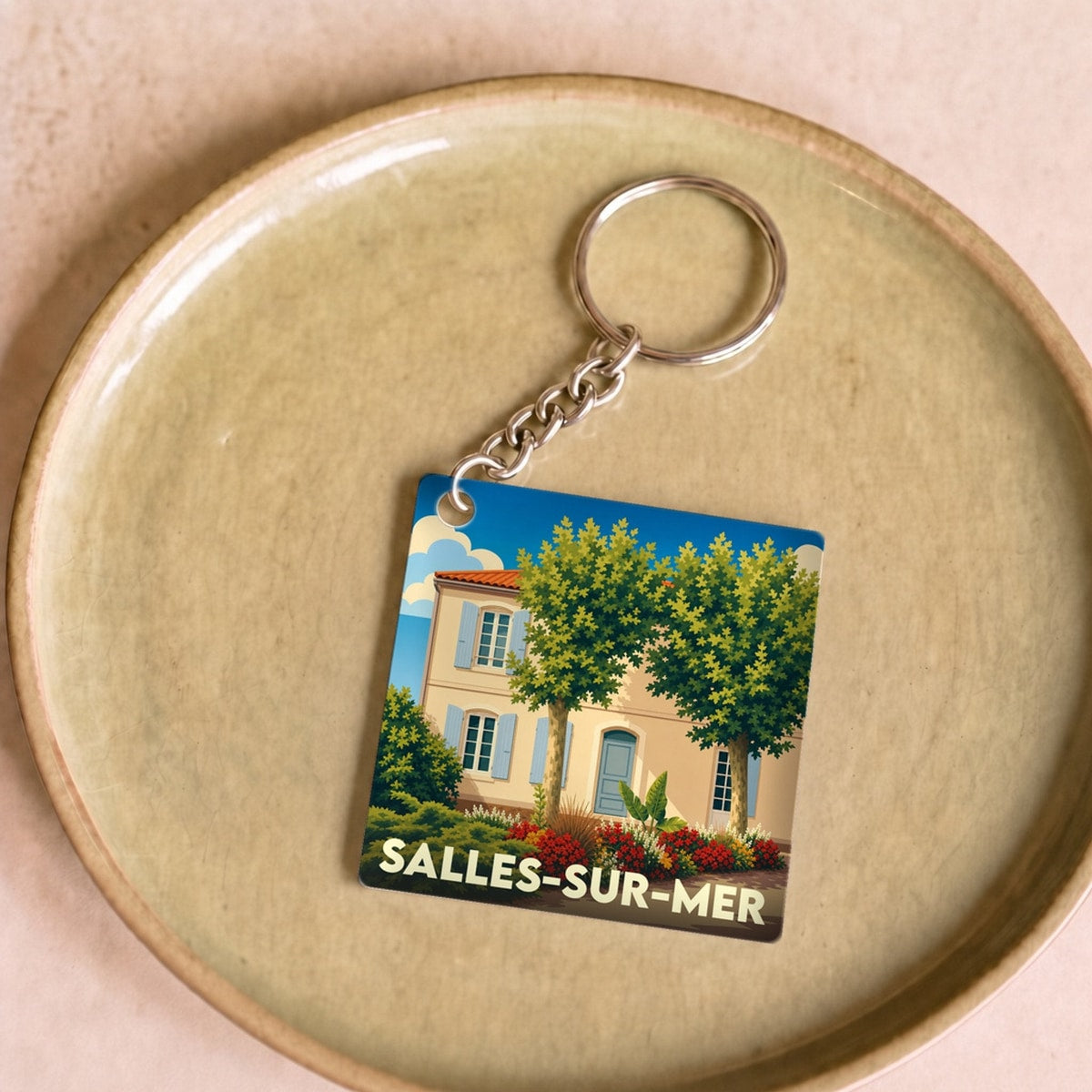 Porte-clés souvenir de la ville de Salles-sur-Mer avec une illustration stylisée.
