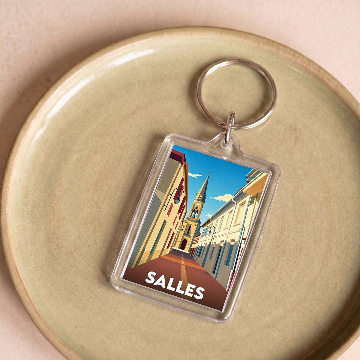 Porte-clés souvenir de la ville de Salles avec une illustration stylisée.
