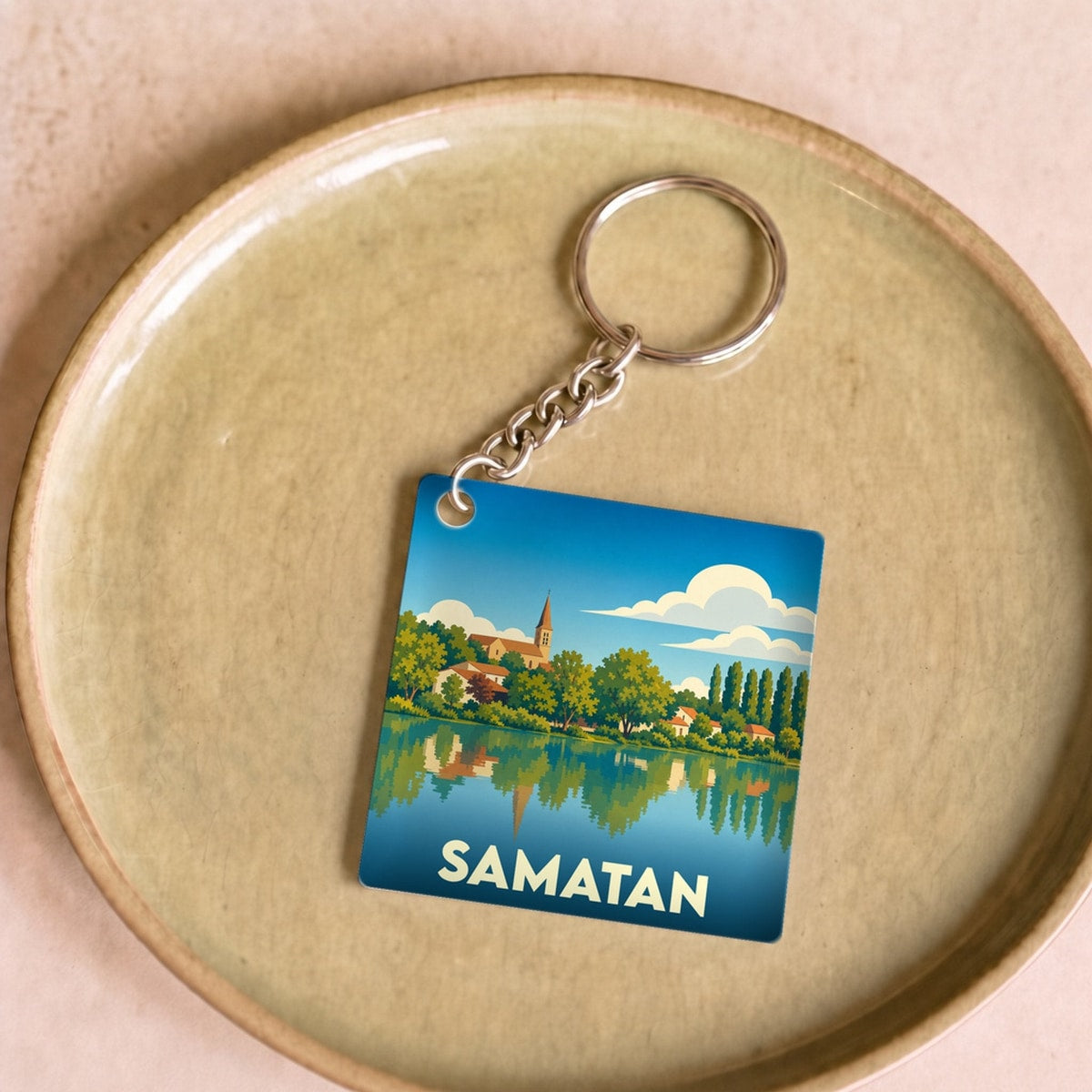 Porte-clés souvenir de la ville de Samatan avec une illustration stylisée des bords du lac.