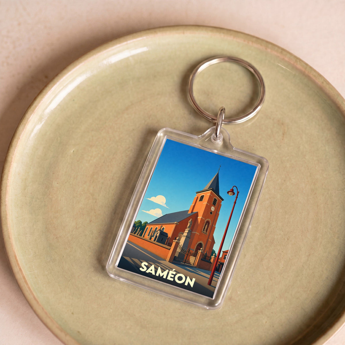 Porte-clés souvenir de la ville de Saméon avec une illustration stylisée de son église.