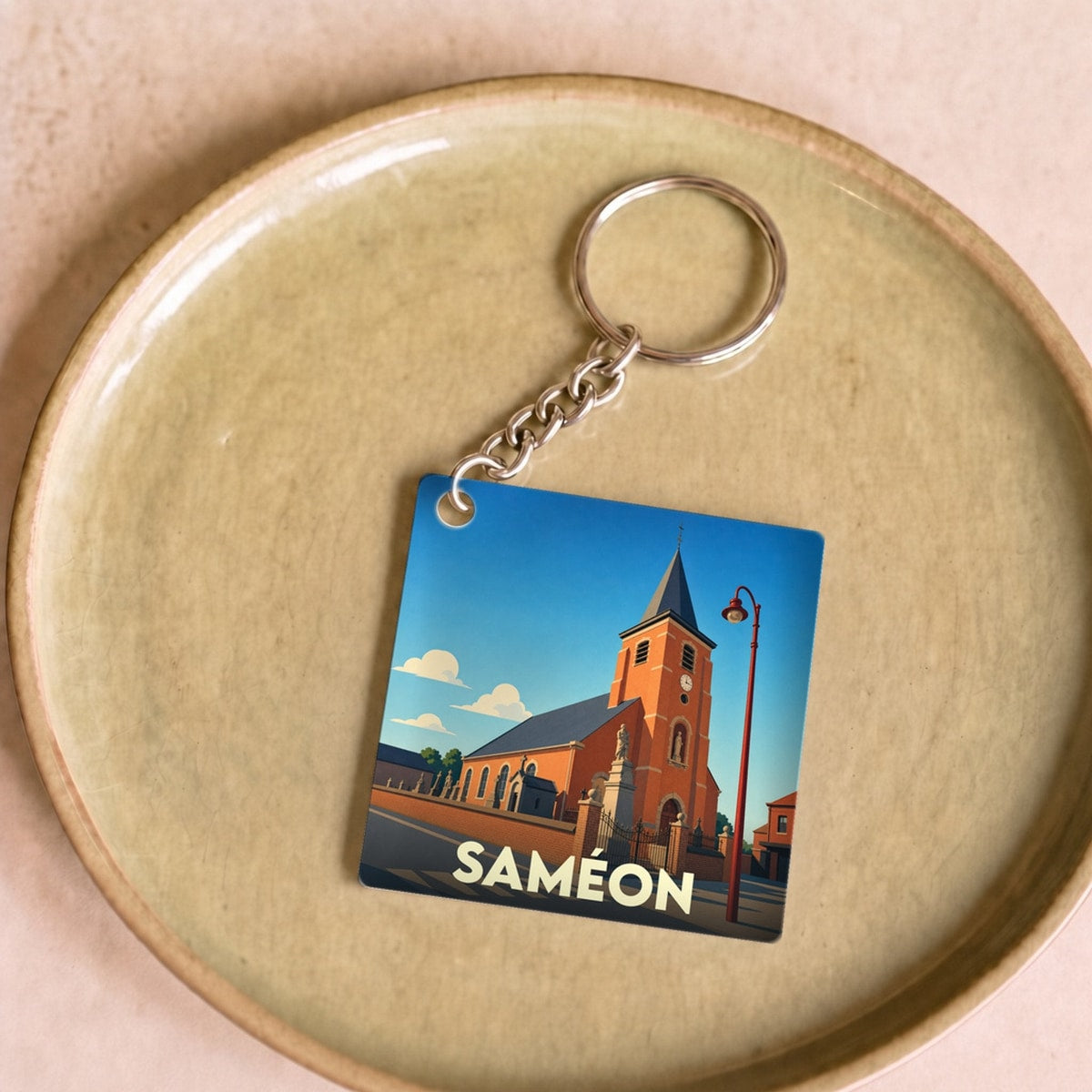 Porte-clés souvenir de la ville de Saméon avec une illustration stylisée de son église.