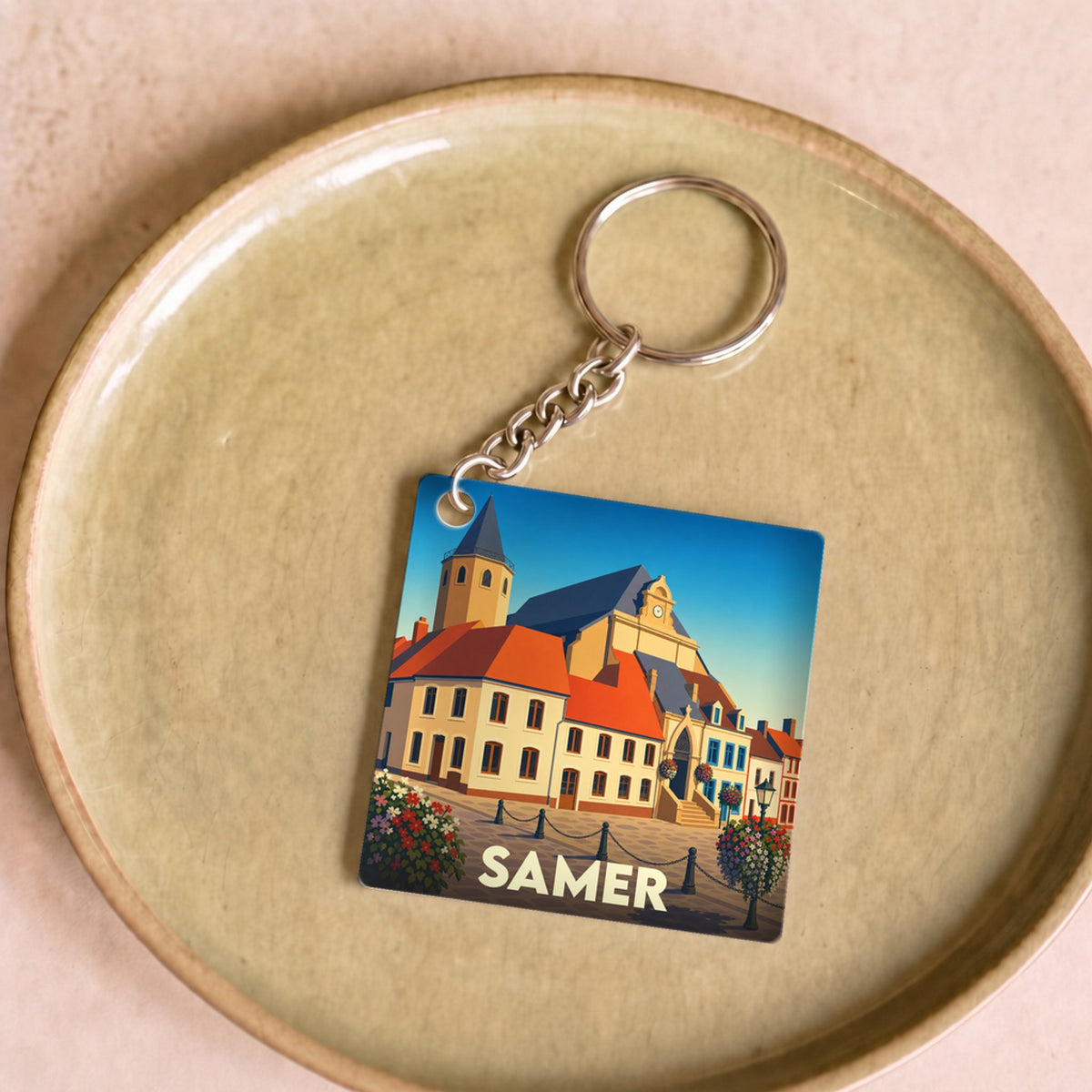 Porte-clés souvenir de la ville de Samer avec une illustration stylisée de son architecture.