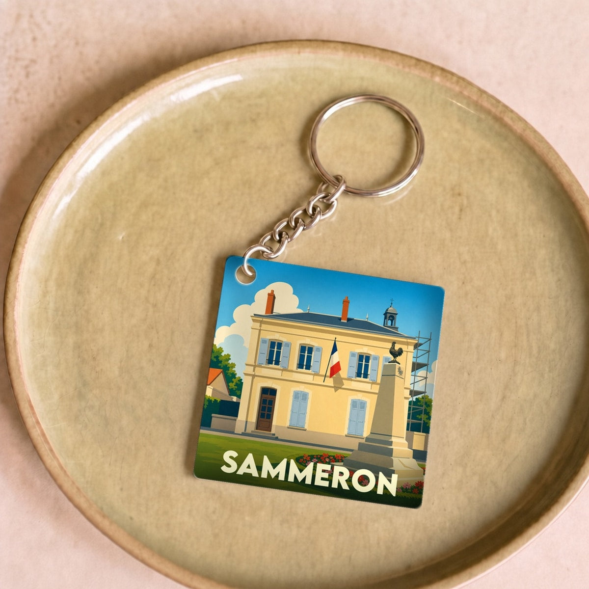 Porte-clés souvenir de la ville de Sammeron avec une illustration stylisée de la mairie.