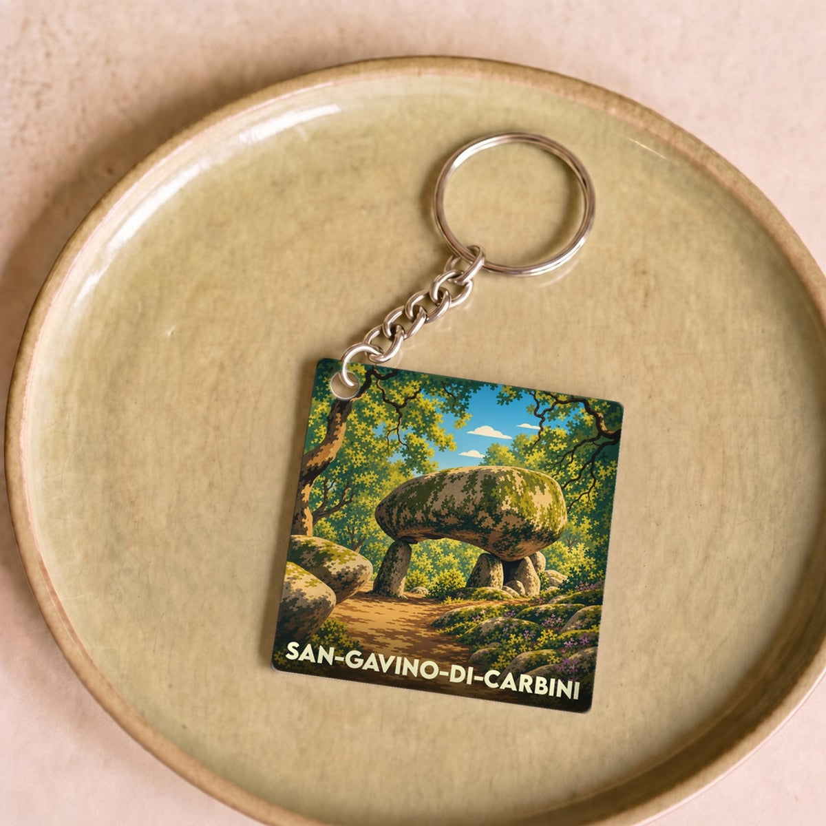 Porte-clés souvenir de San-Gavino-di-Carbini avec une illustration stylisée d'un dolmen en pleine forêt.