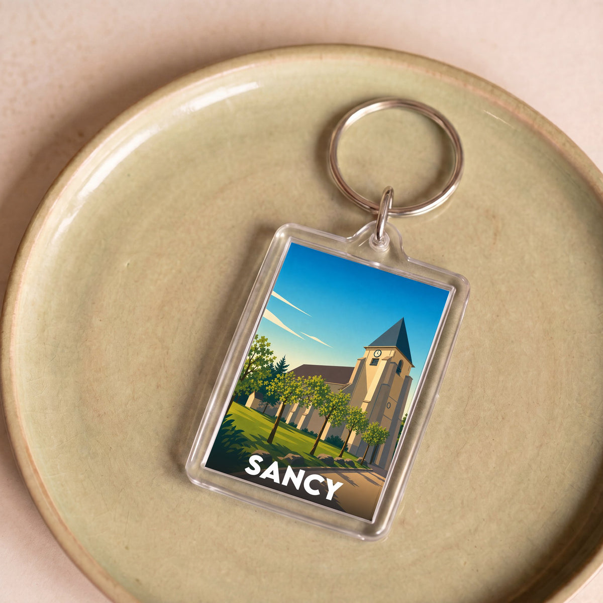 Porte-clés souvenir de la ville de Sancy avec une illustration stylisée.