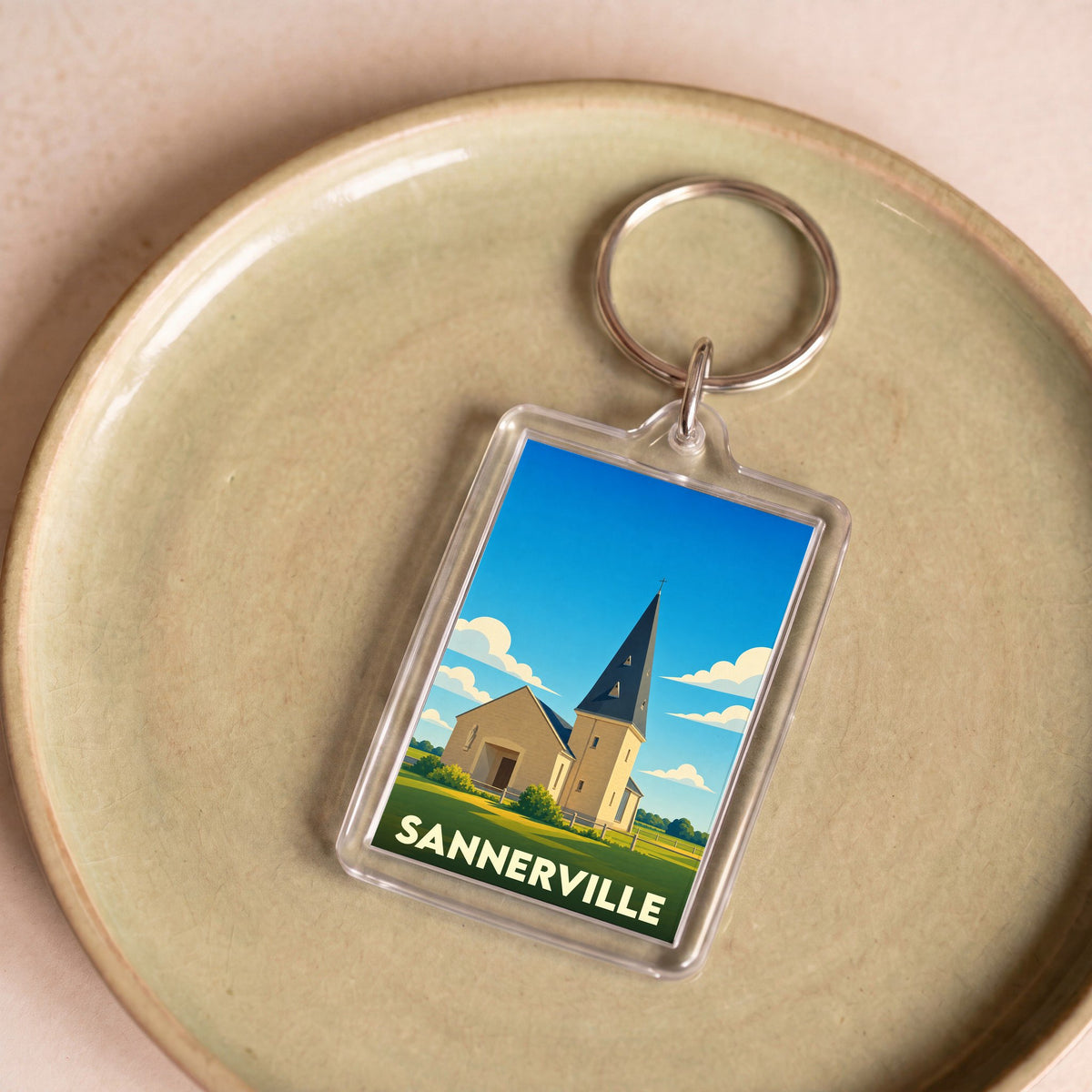 Porte-clés souvenir de la ville de Sannerville avec une illustration stylisée de son église.