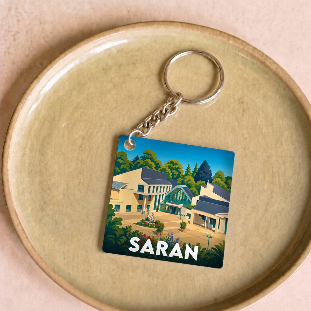 Porte-clés souvenir de la ville de Saran avec une illustration stylisée.