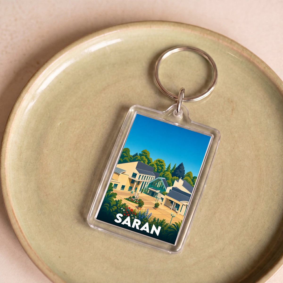Porte-clés souvenir de la ville de Saran avec une illustration stylisée.