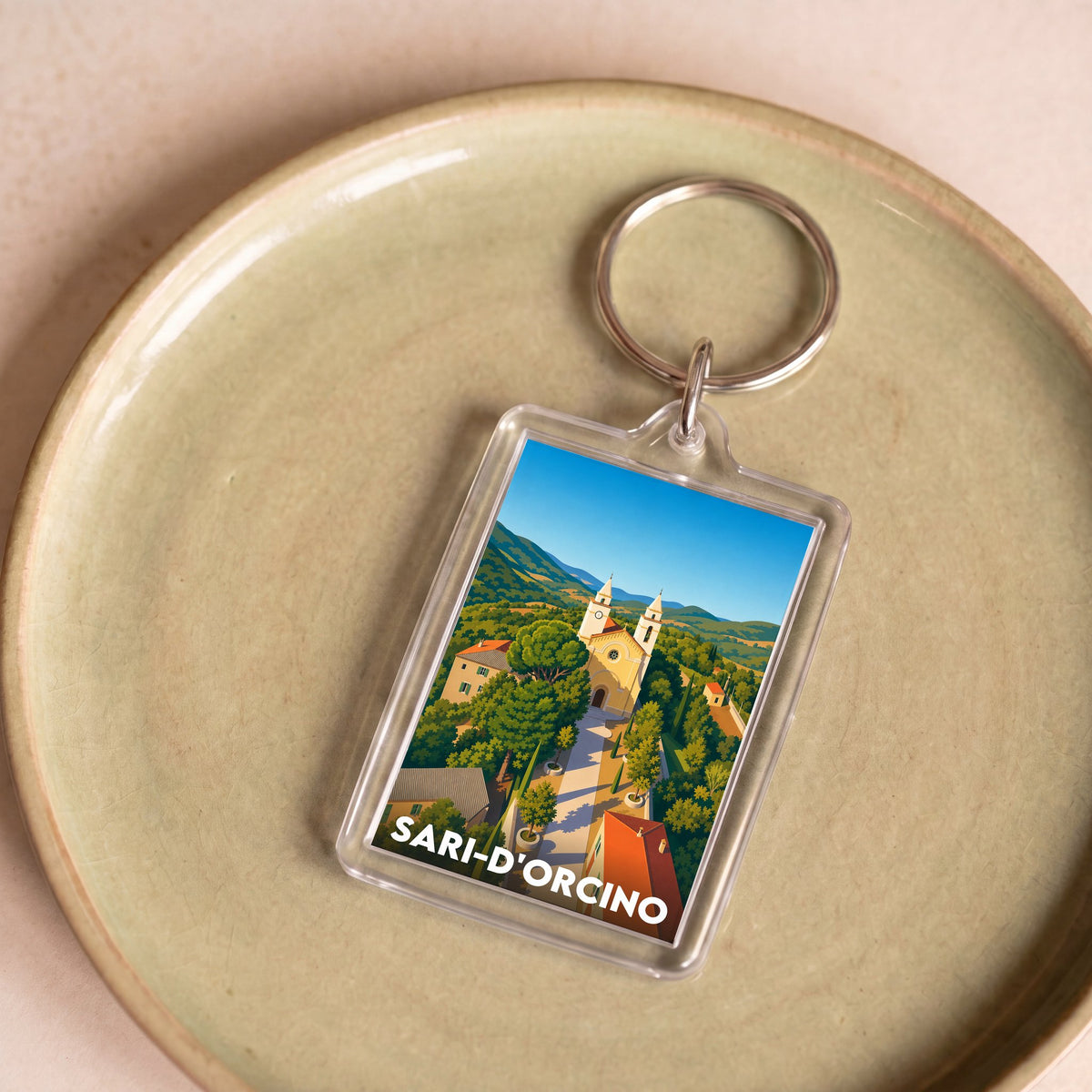 Porte-clés souvenir de la ville de Sari-d'Orcino avec une illustration stylisée du village.