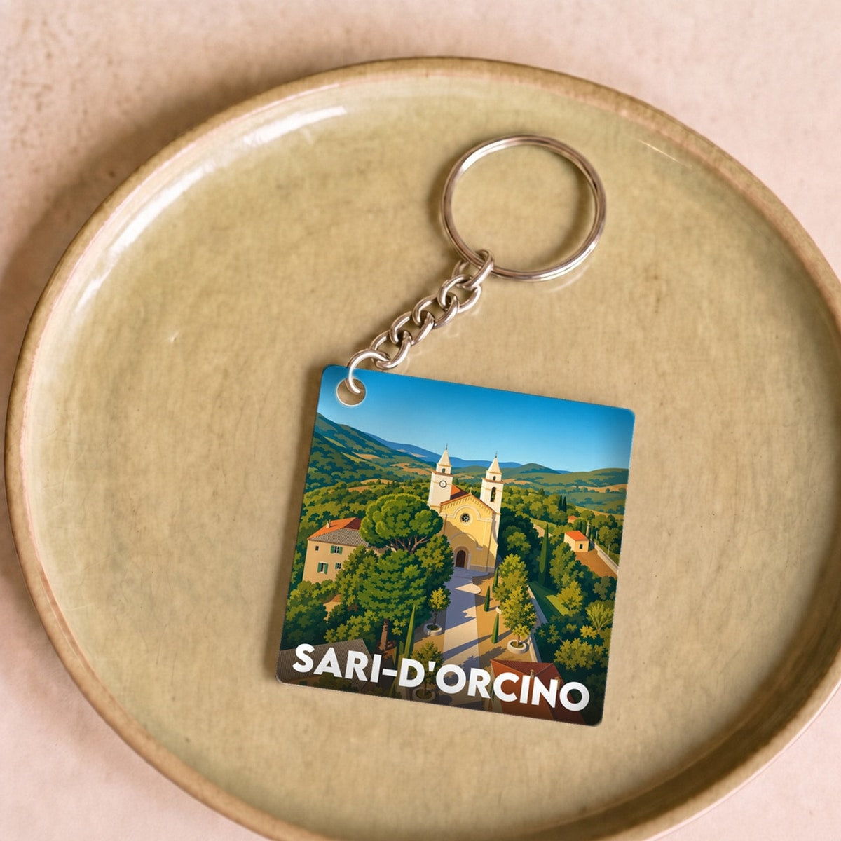 Porte-clés souvenir de la ville de Sari-d'Orcino avec une illustration stylisée du village.