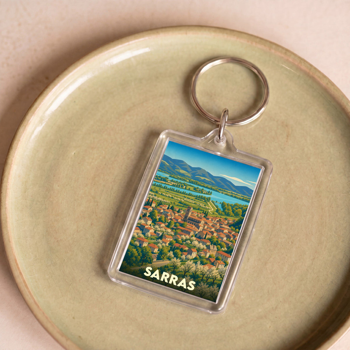 Porte-clés souvenir de la ville de Sarras avec une illustration panoramique stylisée.