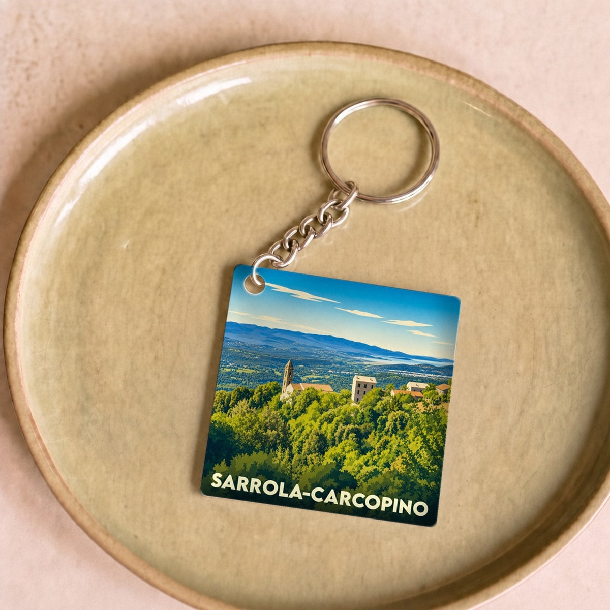 Porte-clés souvenir de la ville de Sarrola-Carcopino avec une illustration stylisée.