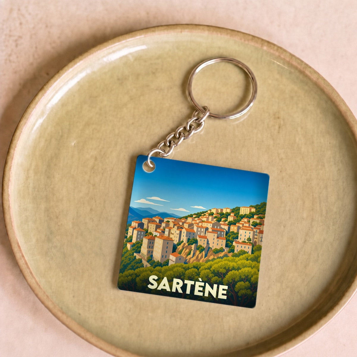 Porte-clés souvenir de la ville de Sartène avec une illustration stylisée.