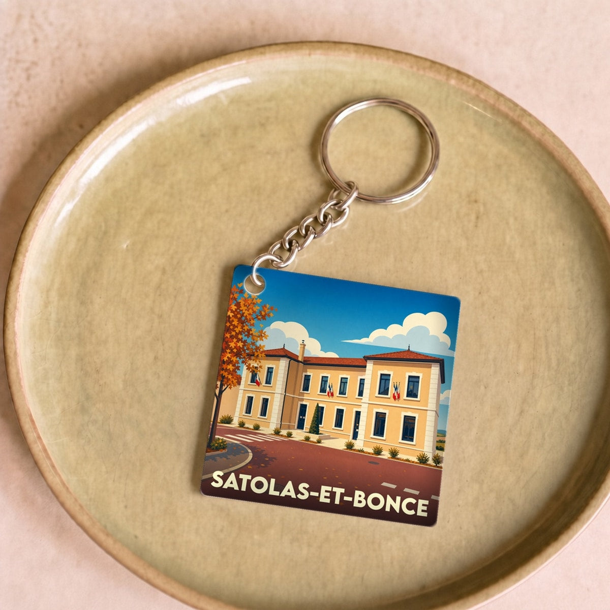 Porte-clés souvenir de la ville de Satolas-et-Bonce avec une illustration stylisée de la mairie.