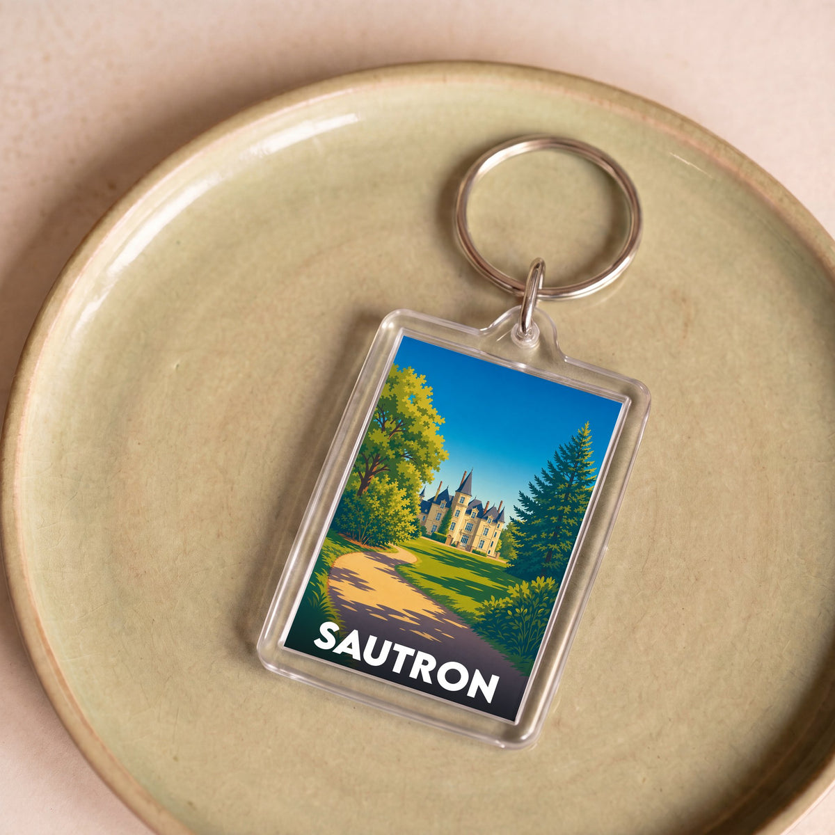 Porte-clés souvenir de la ville de Sautron avec une illustration stylisée d'un château.