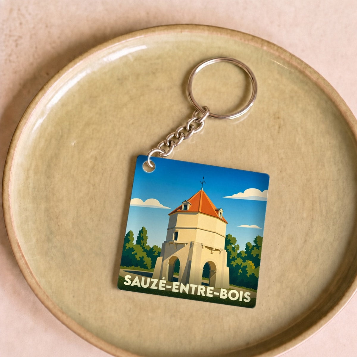 Porte-clés souvenir de la ville de Sauzé-entre-bois avec une illustration stylisée.