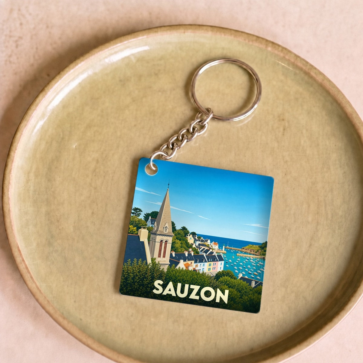 Porte-clés souvenir de la ville de Sauzon avec une illustration stylisée.