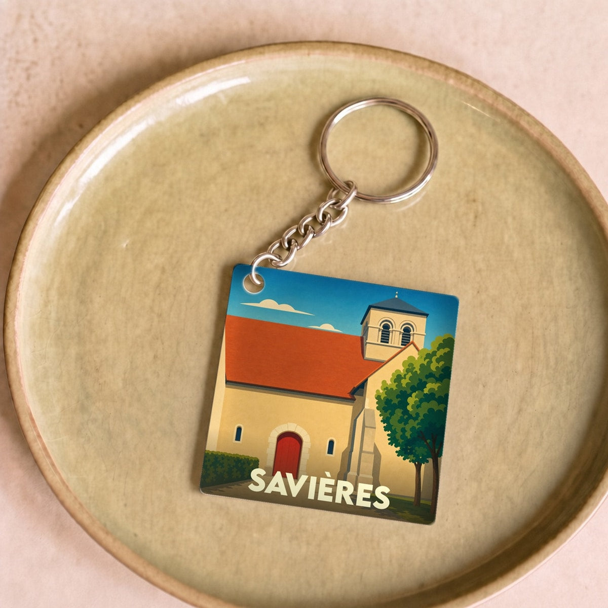 Porte-clés souvenir de la ville de Savières avec une illustration stylisée de son église.