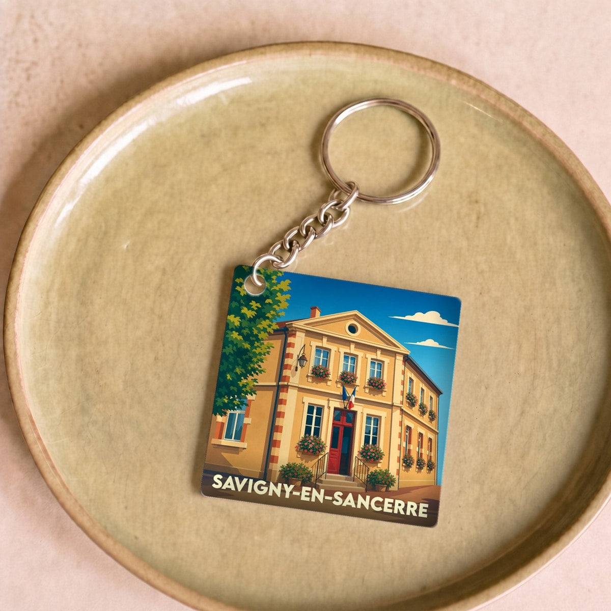 Porte-clés souvenir de la ville de Savigny-en-Sancerre avec une illustration stylisée.