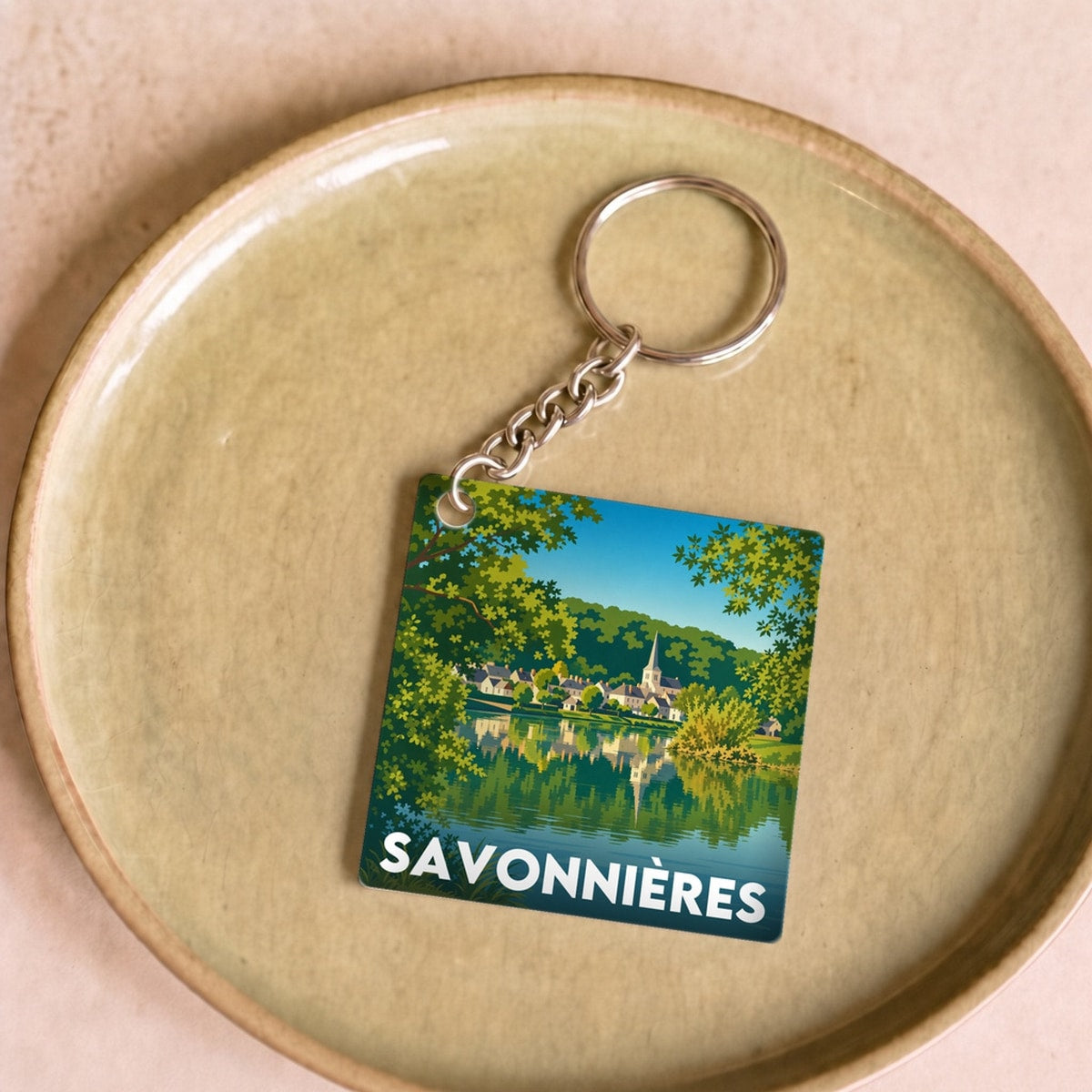 Porte-clés souvenir de la ville de Savonnières avec une illustration stylisée.
