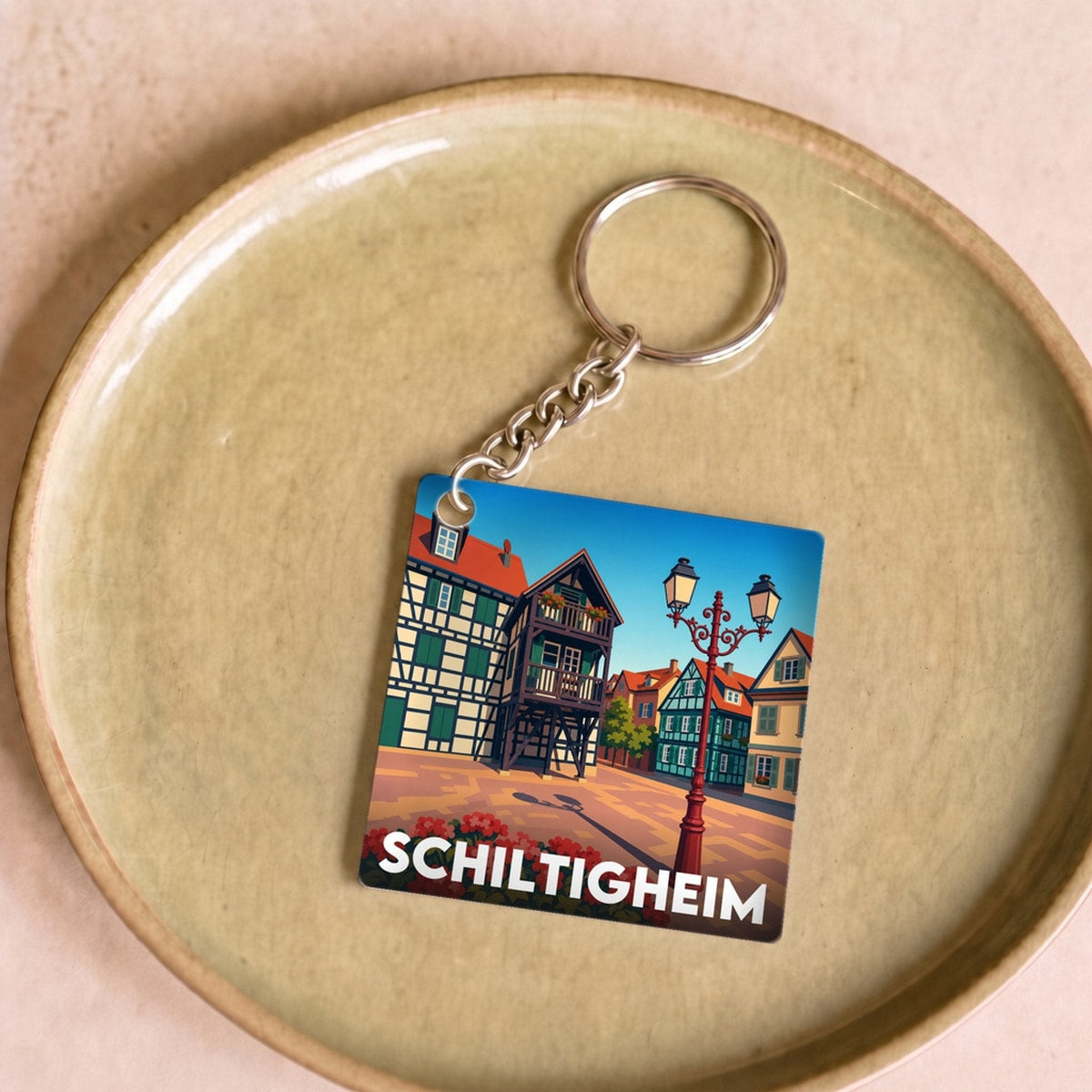 Porte-clés souvenir de la ville de Schiltigheim avec une illustration stylisée de son architecture traditionnelle.