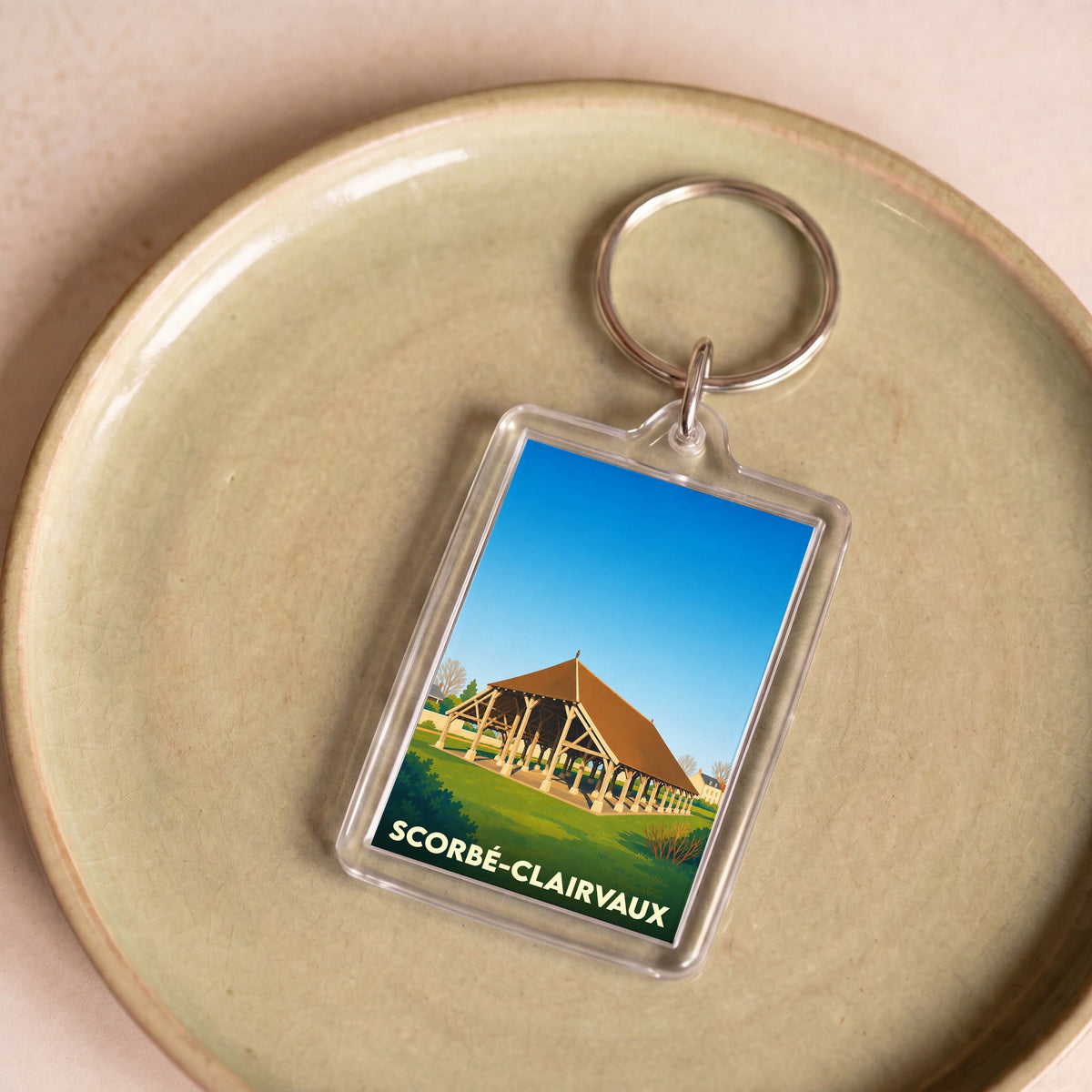 Porte-clés souvenir de la ville de Scorbé-Clairvaux avec une illustration stylisée de ses halles.