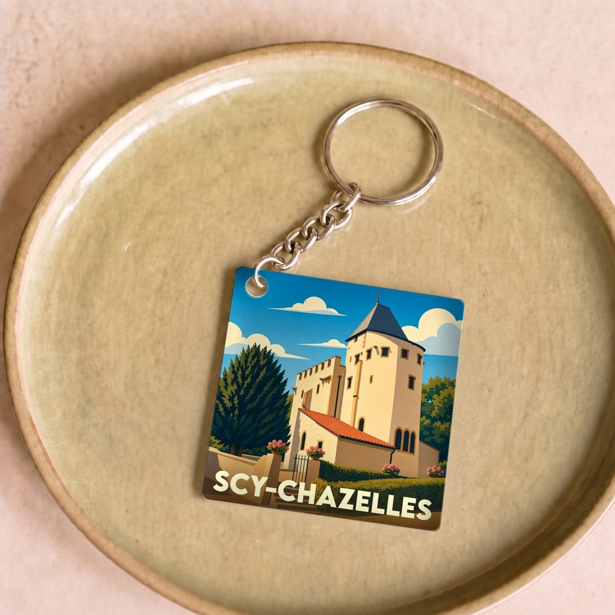 Porte-clés souvenir de la ville de Scy-Chazelles avec une illustration stylisée de son église fortifiée.