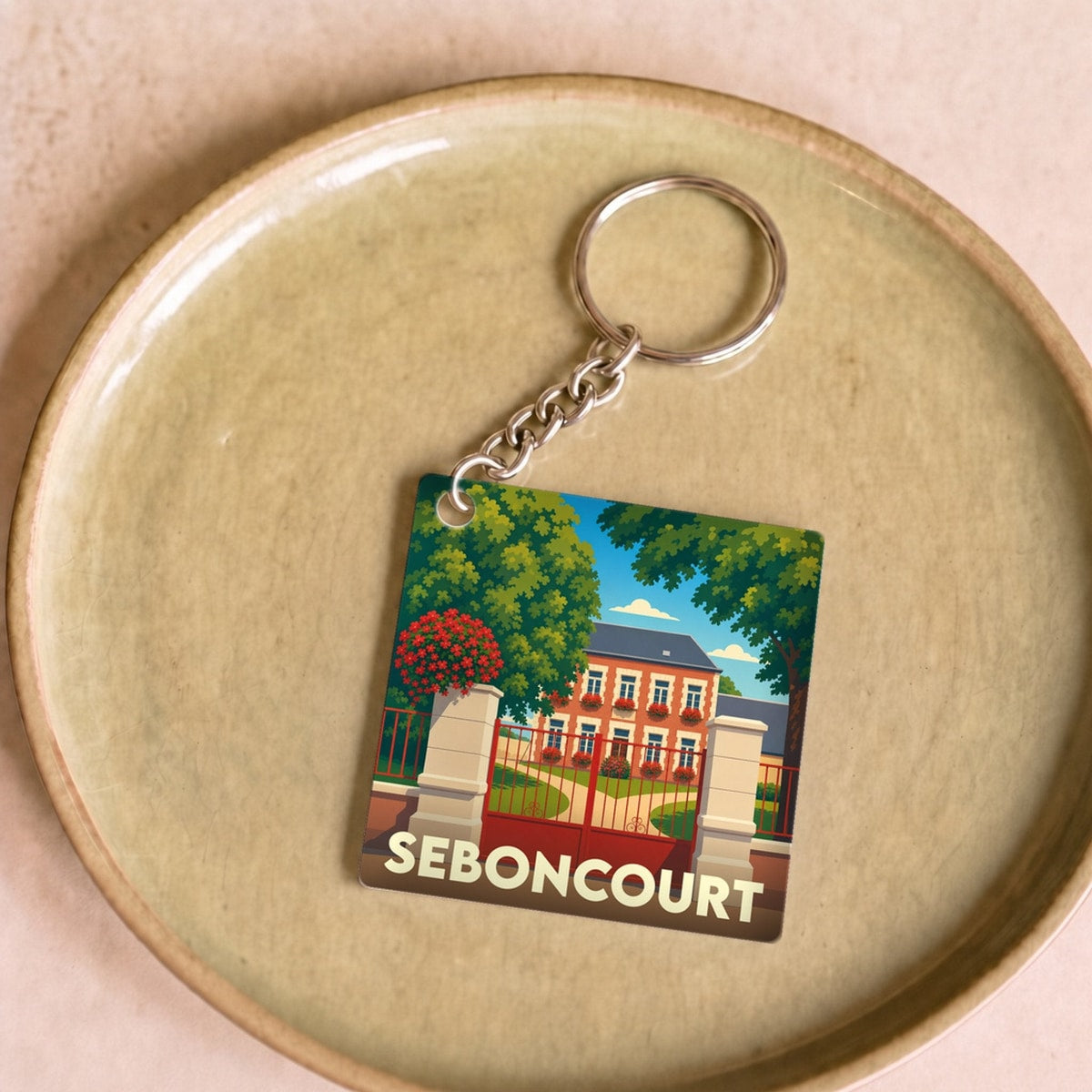 Porte-clés souvenir de la ville de Seboncourt avec une illustration stylisée d'une demeure bourgeoise.