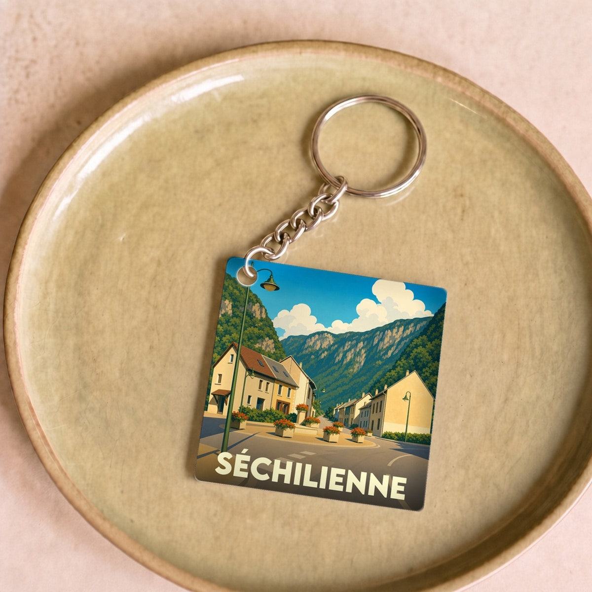 Porte-clés souvenir de la ville de Séchilienne avec une illustration stylisée.