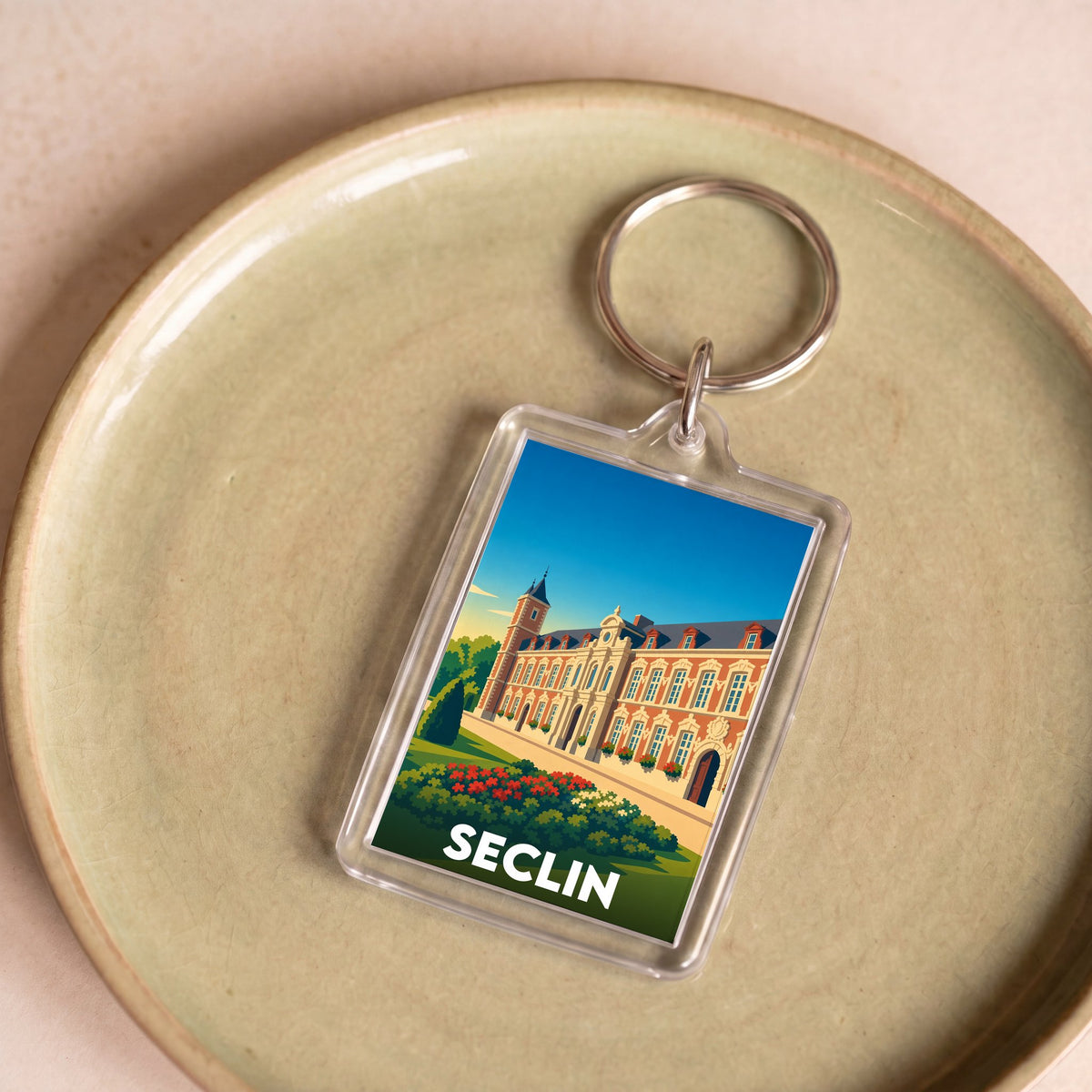 Porte-clés souvenir de la ville de Seclin avec une illustration stylisée d'un monument local.
