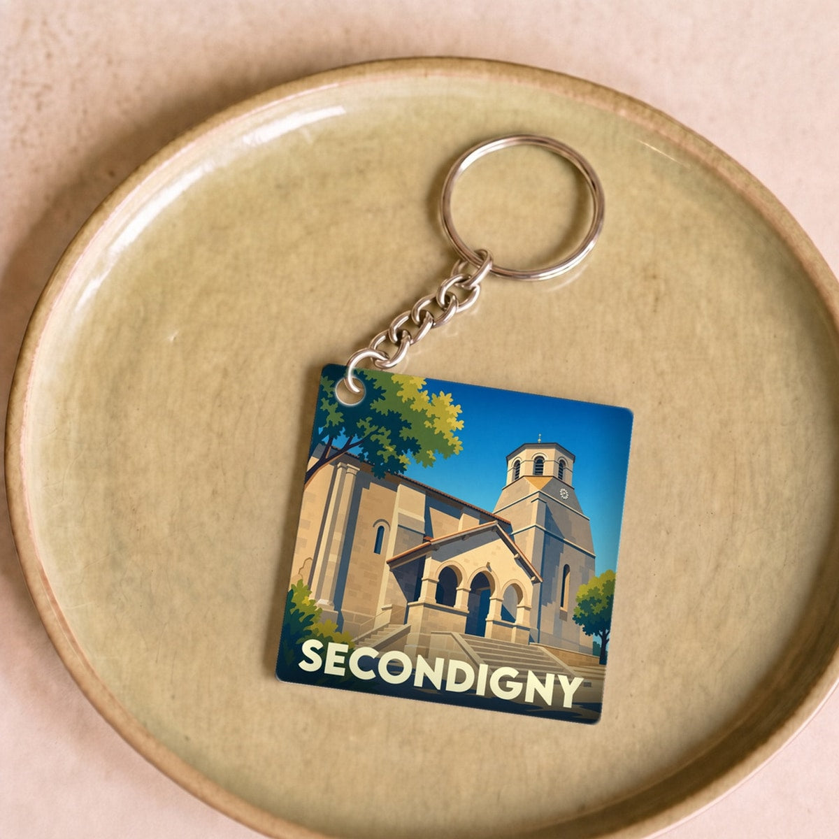 Porte-clés souvenir de la ville de Secondigny avec une illustration stylisée de son église.