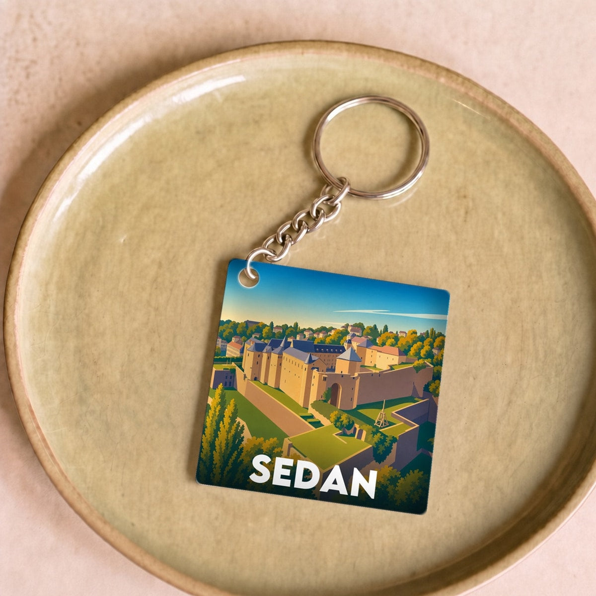 Porte-clés souvenir de la ville de Sedan avec une illustration stylisée.