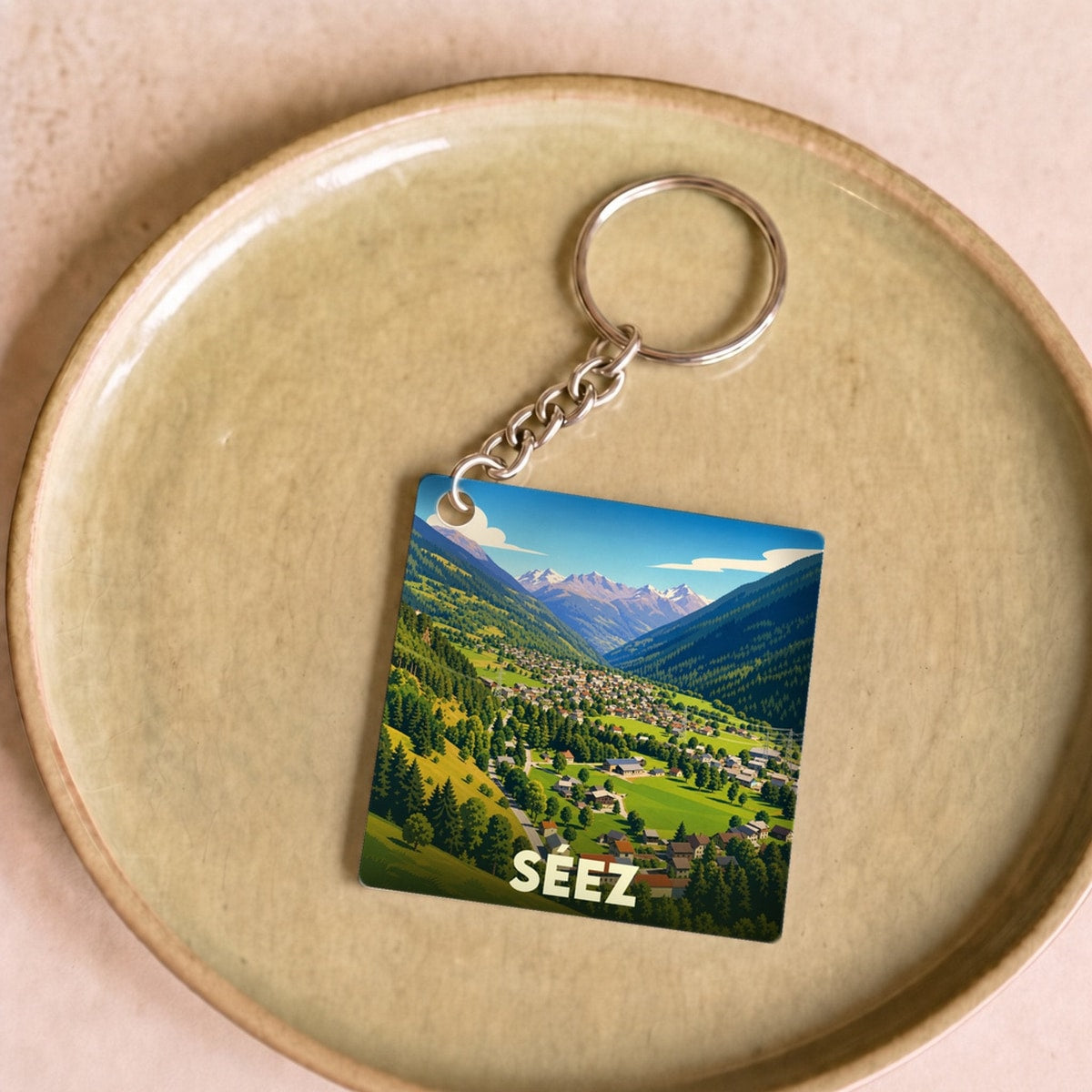 Porte-clés souvenir de la ville de Séez avec une illustration de paysages de montagne.