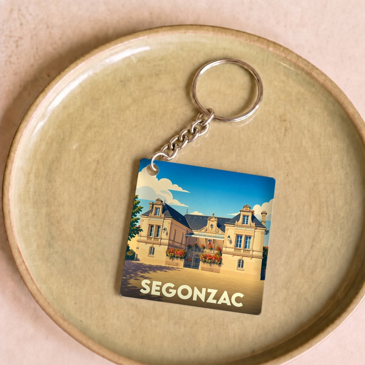 Porte-clés souvenir de la ville de Segonzac avec une illustration stylisée de son hôtel de ville.