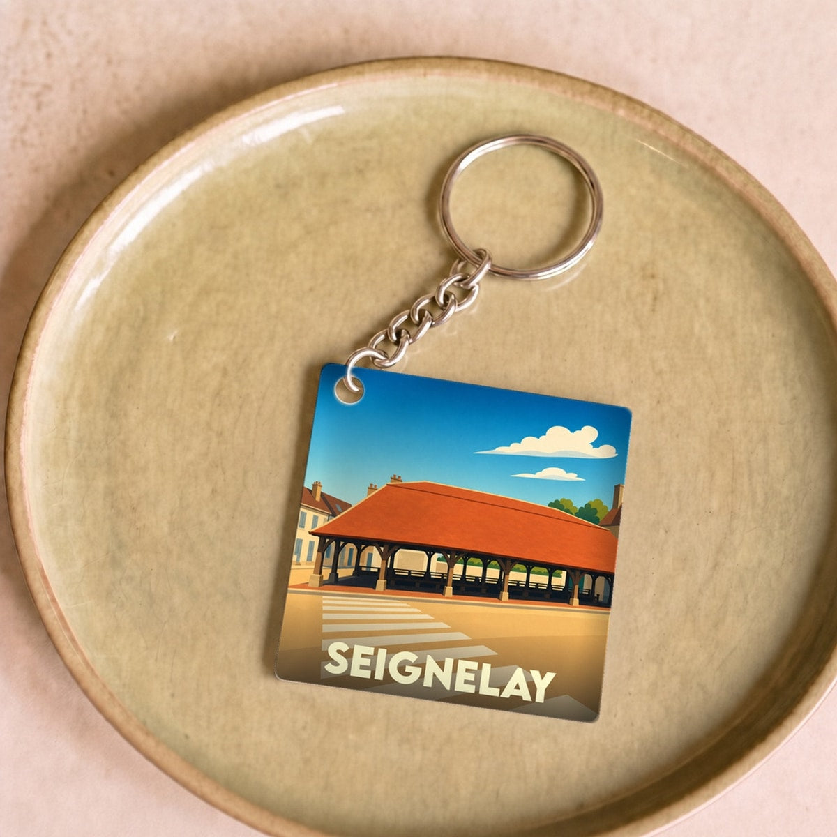 Porte-clés souvenir de la ville de Seignelay avec une illustration stylisée.
