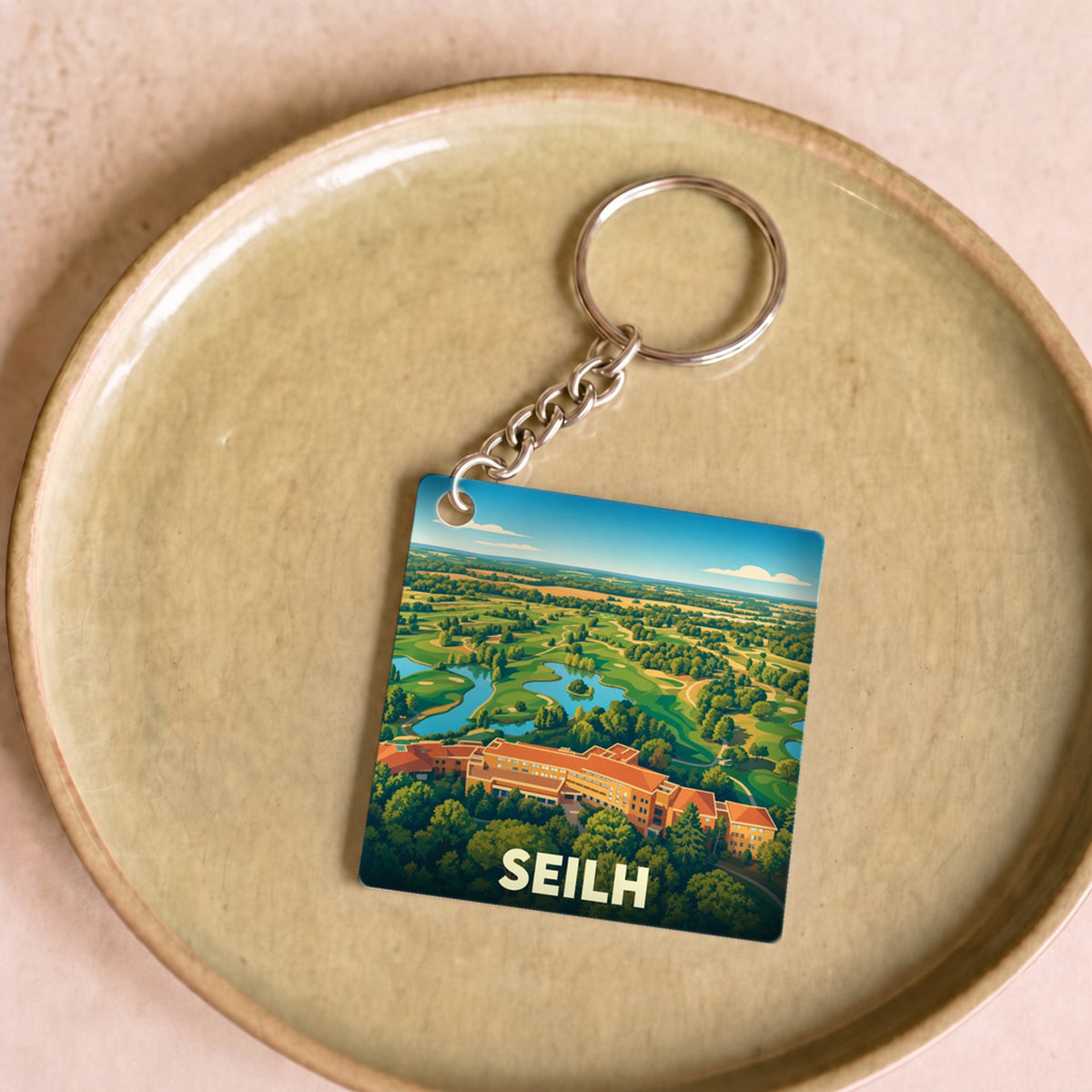 Porte-clés souvenir de la ville de Seilh avec une illustration stylisée de son golf.